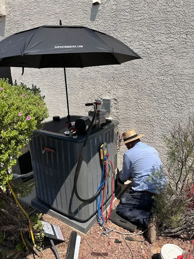HVAC technician performing outdoor AC maintenance in Sioux Center