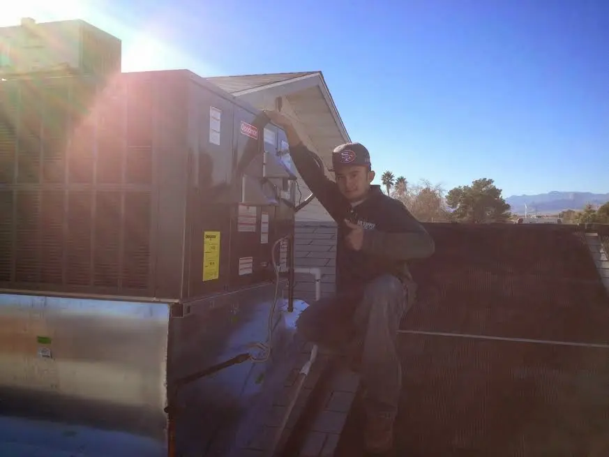 HVAC technician performing Boiler Repair on a rooftop unit in Sioux Center
